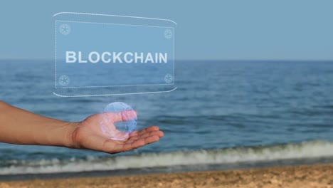 Male-hands-on-the-beach-hold-a-conceptual-hologram-with-the-text-Blockchain