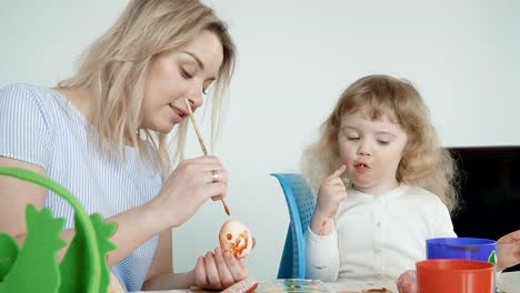 Madre-y-su-hijita-pintando-huevos-de-Pascua