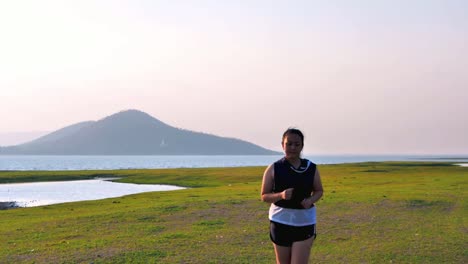 An-Asian-woman-jogging-in-natural-sunlight-in-the-evening.
She-is-trying-to-lose-weight-with-exercise.--concept-health-with-exercise.-Slow-Motion