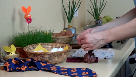 hands-put-white-egg-into-silk-material.-Easter-eggs-painting.