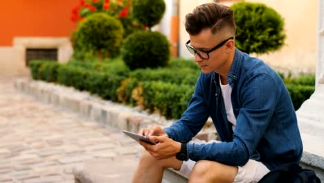 Young-man-using-smart-phone-for-chatting-with-friends-in-the-city-centre.