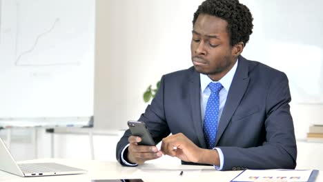 African-Businessman-Using-Smartphone,-Texting-Message