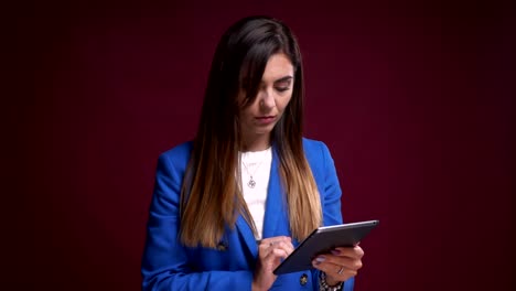 Closeup-portrait-of-attractive-caucasian-female-using-the-tablet-standing-in-front-of-the-camera