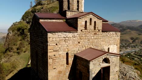 vista-aérea-4K-UHD-de-un-monasterio-de-montaña-de-pie-sobre-un-acantilado