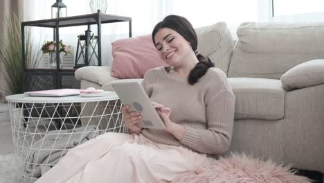 Woman-having-fun-using-digital-tablet-at-home