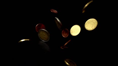 Coins-fall-on-a-black-background.-Slow-motion.