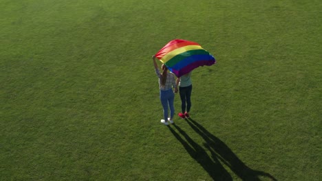 Drone-flight-over-gay-couple-holding-lgbt-flag