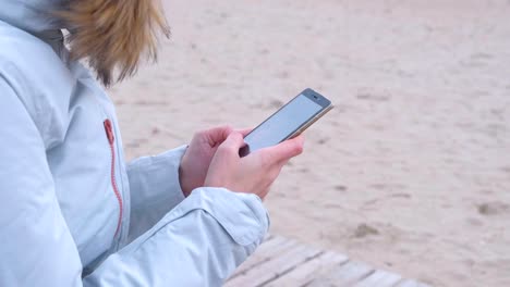 Nahaufnahme-Frau-Hände-tippen-einen-Beitrag-in-sozialen-Medien-auf-dem-Telefon-auf-See-Hintergrund.