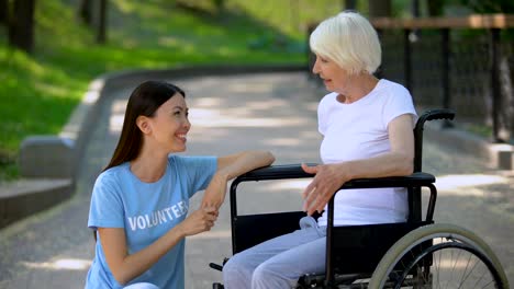 Behinderte-Seniorin-im-Rollstuhl-im-Gespräch-mit-Freiwilligen,-Gesprächsunterstützung