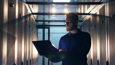 Male-IT-specialist-is-operating-a-laptop-in-a-server-room