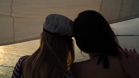 lesbian-partners-hugging-on-sailboat-and-watching-sunset