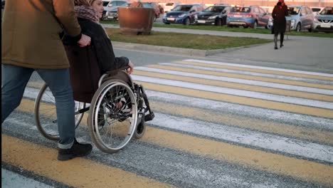 Man-pushing-the-wheelchair-with-handicapped-girlfriend-across-the-street