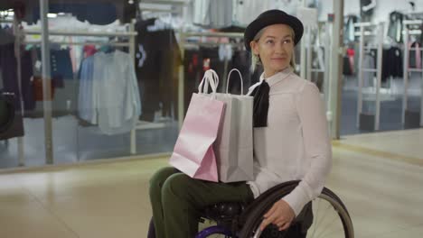 Stylish-Paraplegic-Woman-in-Wheelchair-Riding-through-Mall