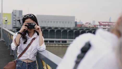 Asiatische-lesbische-Paare-genießen-Reisen-mit-Filmkamera-ein-Foto.-Zwei-schöne-junge-Frauen,-die-Spaß-in-der-Ferienzeit-haben.