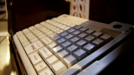 Side-View-Mujer-Cajero-funciona-en-la-máquina-con-teclado-blanco