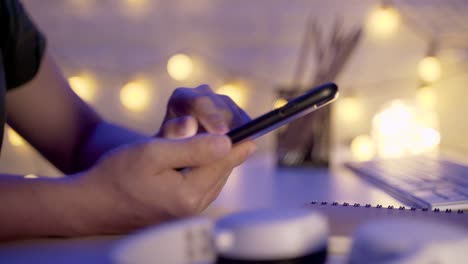 Foto-de-cerca-de-manos-femeninas-usando-teléfono-inteligente-en-la-oficina-por-la-noche