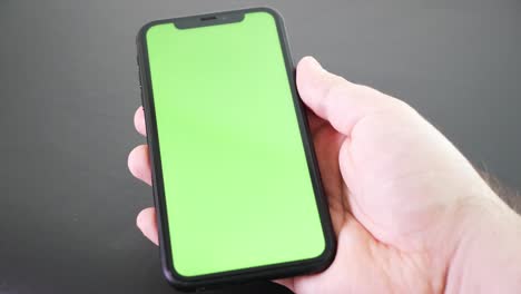 Hand-holding-mobile-phone-with-green-screen.-Chroma-key