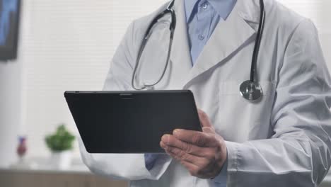 close-up-of-a-doctor-using-tablet-behind-a-glass