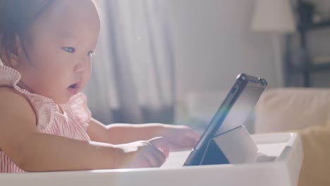 Asiatische-Baby-Mädchen-spielen-mit-digitalen-Tablet