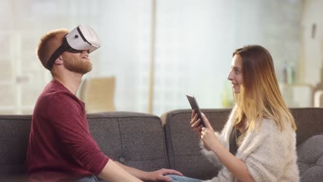 Junge-süße-paar-auf-Couch-mit-VR-zu-spielen-und-Spaß-haben