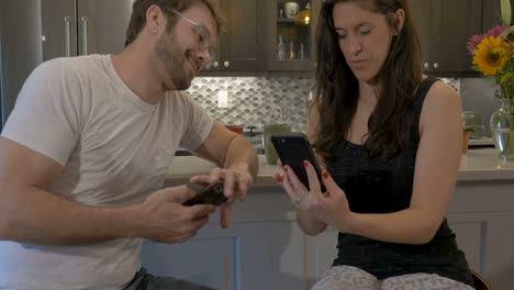 Wunderschöne-Frau-mit-einem-attraktiven-Mann,-Blick-auf-ein-Handy-zusammen-lachen