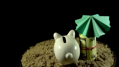 A-white-piggy-bank-stands-on-a-sandy-beach-and-spins-on-a-black-background.