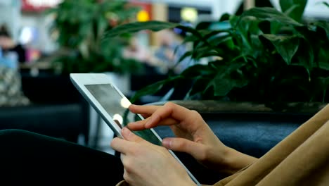 Businesswoman-uses-a-tablet-in-the-business-center-close-up