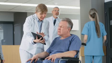 En-el-Hospital-femenino-médico-muestra-Tablet-PC-al-paciente-mayor,-explicando-su-condición.-Moderno-Hospital-con-la-mejor-atención-posible.