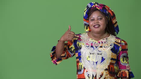 Overweight-beautiful-African-woman-wearing-traditional-clothing-against-green-background