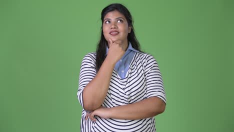 Young-overweight-beautiful-Indian-businesswoman-against-green-background