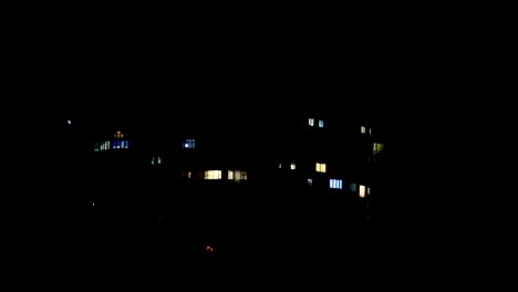 Facade-with-many-windows,-exterior-of-a-modern-apartment-block-at-night,-close-up,-shallow-depth-of-the-field,-59,94-fps