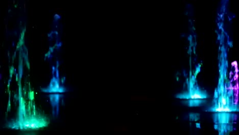 Colored-water-night-fountain-dancing-with-lights-multicolored-blur-footage-background,-close-up,-shallow-depth-of-the-field,-59,94-fps