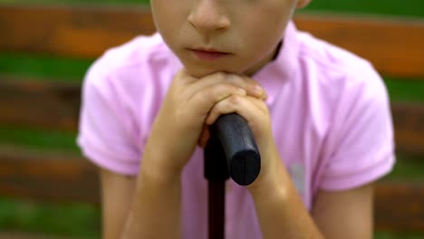 Upset-boy-with-cane-feels-lonely,-has-no-friends,-difficult-life-for-disabled