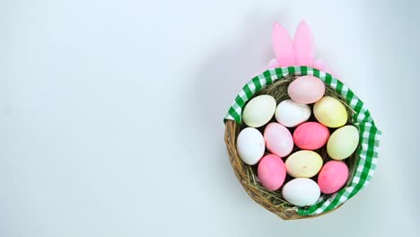 Female-hands-putting-Easter-present-basket-on-table,-colored-eggs,-handmade-gift