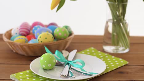 easter-eggs-in-basket-and-flowers-on-served-table