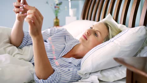 Beautiful-Blond-Woman-Checking-Her-Smart-Phone-After-Waking-Up