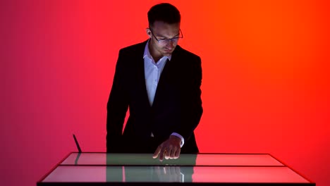 The-businessman-working-with-a-touchscreen-in-the-red-room