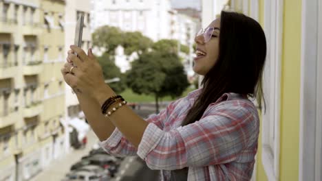 Mujer-joven-feliz-en-gafas-con-video-llamada-a-través-de-la-tableta.