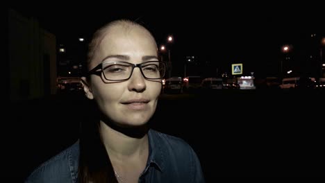 Portrait-of-young-beautiful-caucasian-woman-using-smart-phone-hand-hold-outdoor-in-the-city-night,-smiling,-face-illuminated-screenlight---social-network,-technology,-comunication-concept