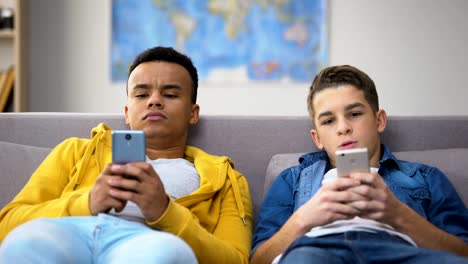 Amigos-adolescentes-multirraciales-jugando-juegos-en-smartphones,-ignorándose-mutuamente