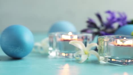 Blue-easter-eggs,-candles-and-white-hyacinth-on-blue-concrete-table-surface-background,-copy-space-for-you-text.-Festive-background.-Happy-Easter-greeting-card.