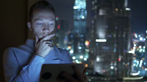 Young-man-using-tablet-to-speak-and-communicate-with-skyscraper-view-background