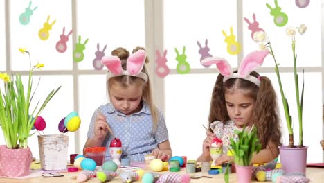 Happy-children-wearing-bunny-ears-painting-eggs-on-Easter-day.