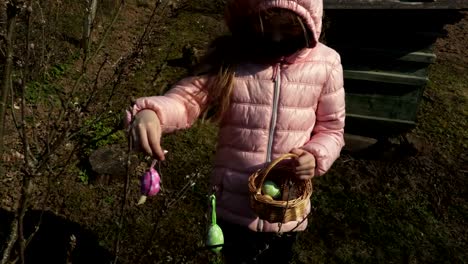 Girl-with-Easter-decorations-near-bush-at-outdoor