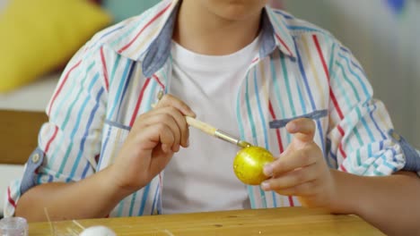 Pequeño-niño-muriendo-huevo-de-Pascua-con-color-dorado