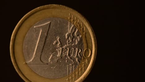 One-euro-Coin-está-girando-sobre-un-fondo-negro.