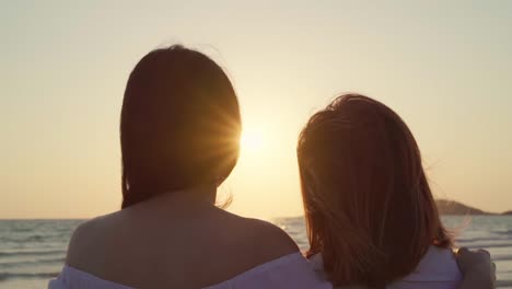 Slow-motion---Young-Asian-lesbian-couple-kissing-near-beach.-Beautiful-women-lgbt-happy-relax-enjoy-love-and-romantic-moment-when-sunset-in-evening.-Lifestyle-lesbian-couple-travel-on-beach-concept.