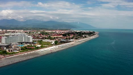 Aerial-video-shooting.-The-black-sea-coast-of-Sochi,-Russia.-Mountain-view.-A-place-of-rest-and-entertainment.-Hotels-and-houses-on-the-coast.-Infrastructure-for-recreation-and-entertainment.