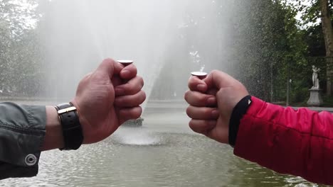 Männliche-und-weibliche-Hand-wirft-eine-Münze-in-den-Brunnen-für-viel-Glück.