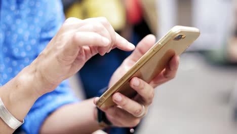 Close-up-footage-of-woman's-hands-holding-smartphone-and-browsing-website.